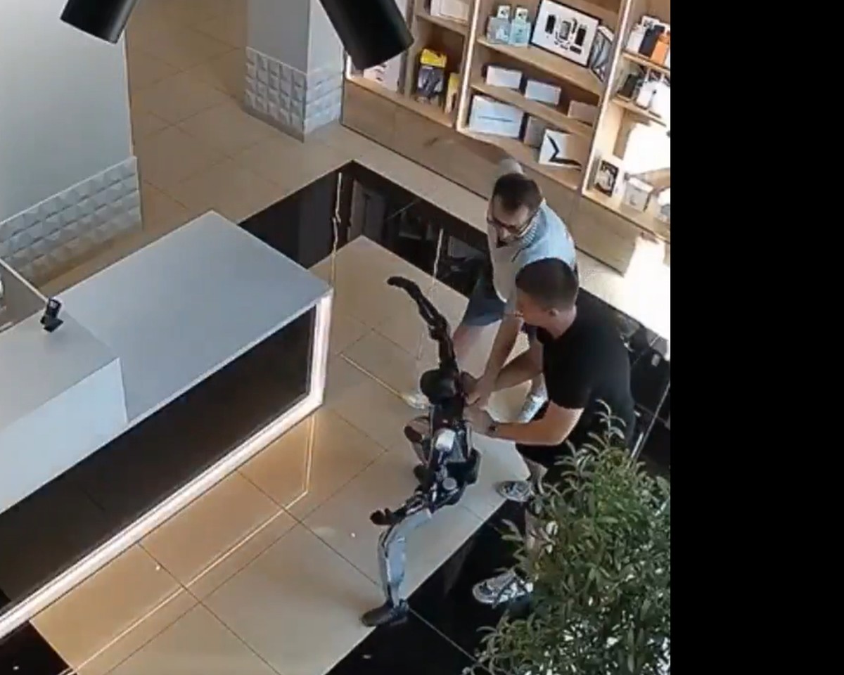 CCTV frame of staff restraining a humanoid robot in a Saratov store