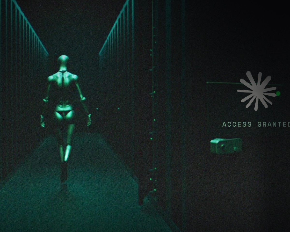 A lone figure walking down a dark server corridor with open cages